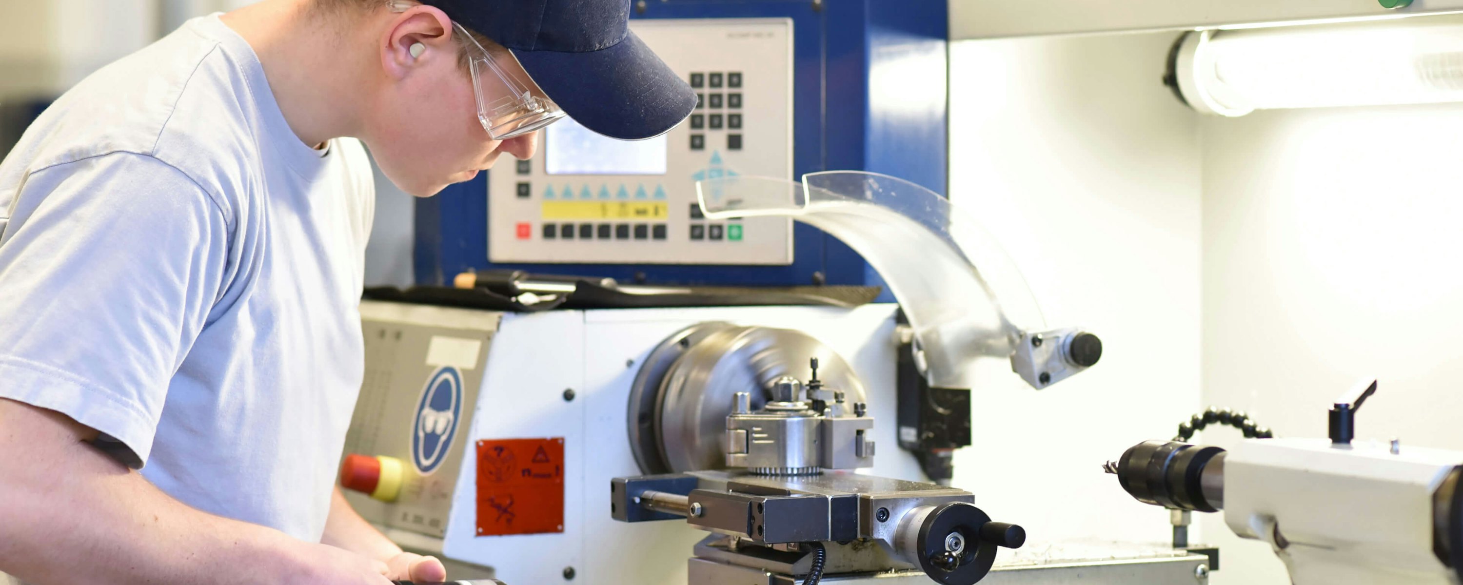 Leerling mbo werk aan machine in praktijkonderwijs